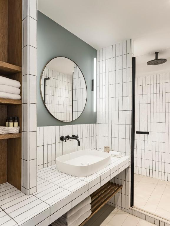 a bathroom with a tub and a mirror at Hôtel & Spa Belle Plage in Cannes
