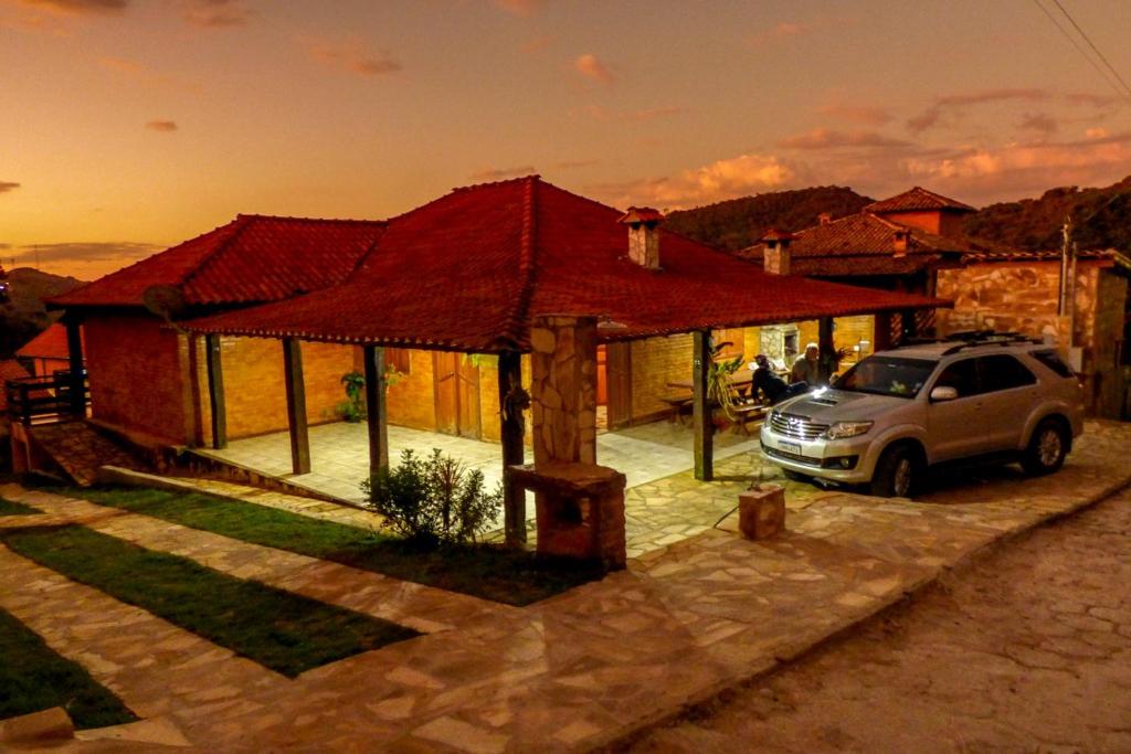 a house with a car parked in front of it at Casa do Eduardo ibitipoca mg in Conceição da Ibitipoca