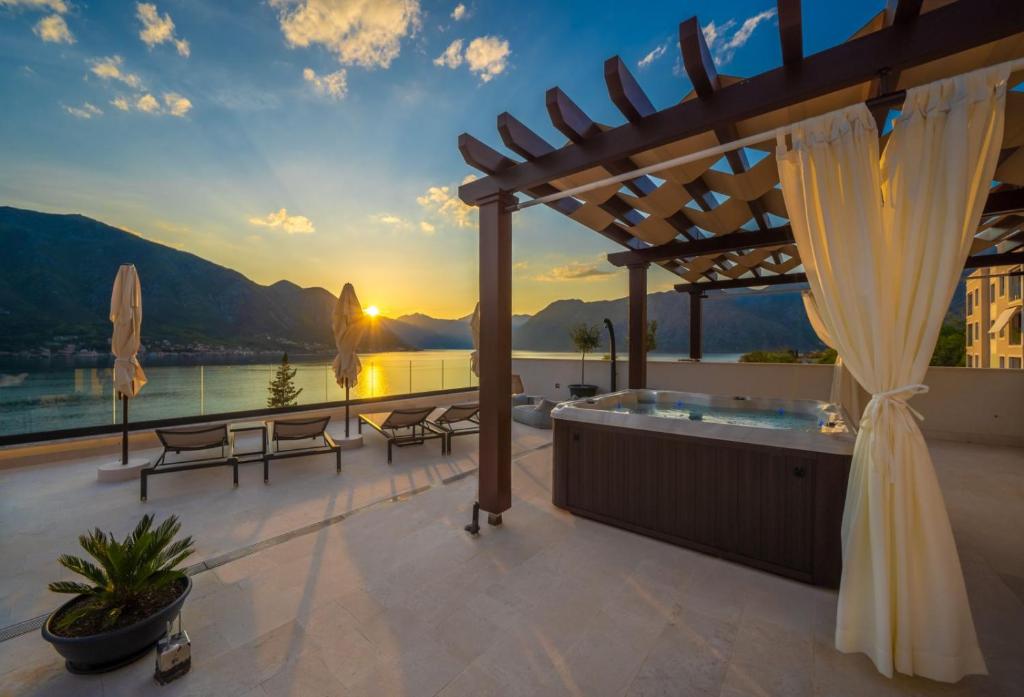 a patio with a hot tub and a view of the water at Boutique Hotel R Palazzo in Kotor
