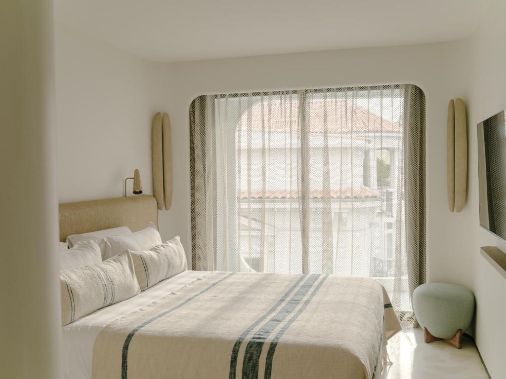 a bedroom with a bed and a large window at Hôtel & Spa Belle Plage in Cannes