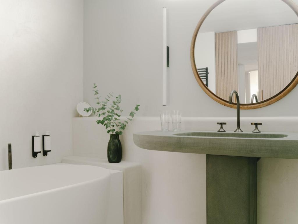 a bathroom with a green sink and a mirror at Hôtel & Spa Belle Plage in Cannes