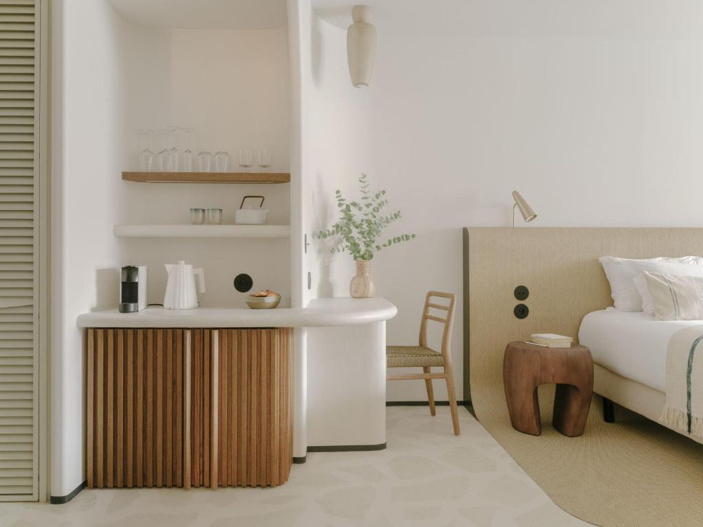 a bedroom with a bed and a table and a chair at Hôtel & Spa Belle Plage in Cannes