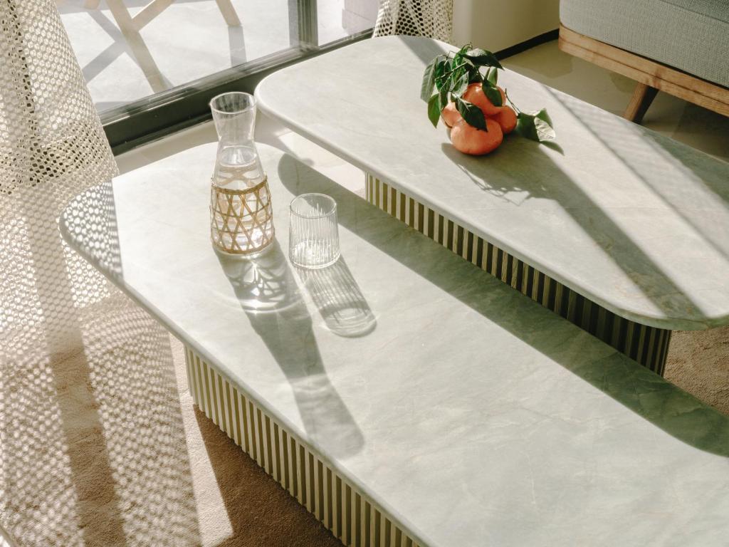 a table with two glasses and a vase on it at Hôtel & Spa Belle Plage in Cannes