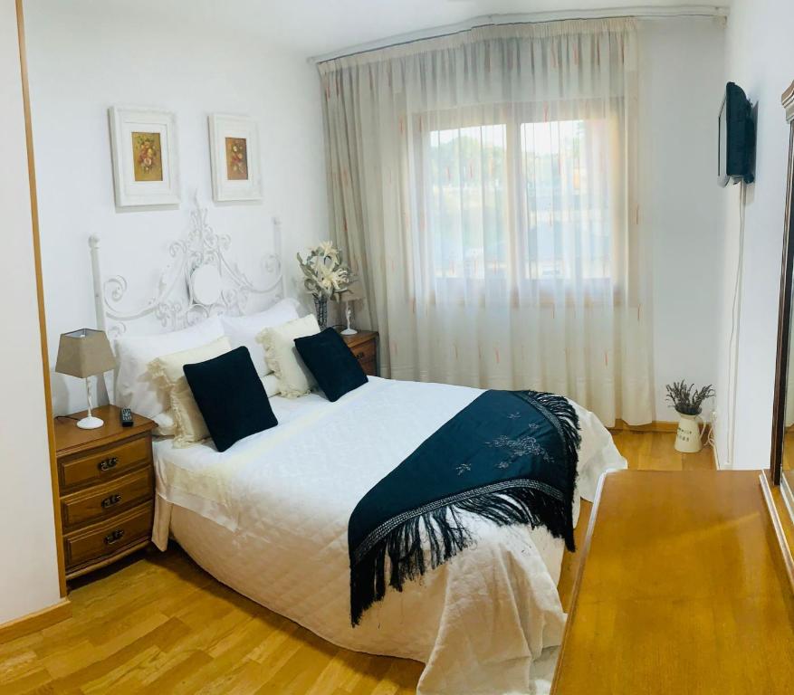 a bedroom with a large bed and a window at Apartamento en el centro de Ribeira con parking incluído in Ribeira