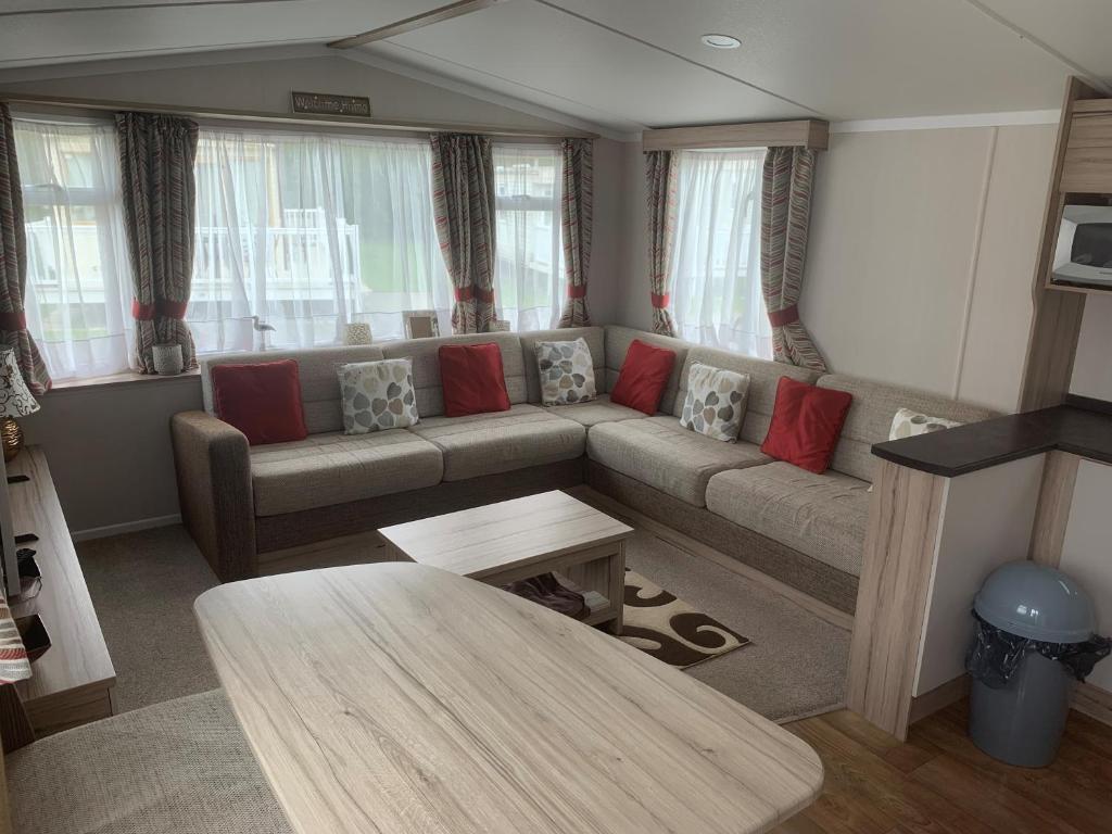 a living room with a couch and a table at CLJP Caravan Thorpe Park Cleethorpes Free WI-FI in Cleethorpes