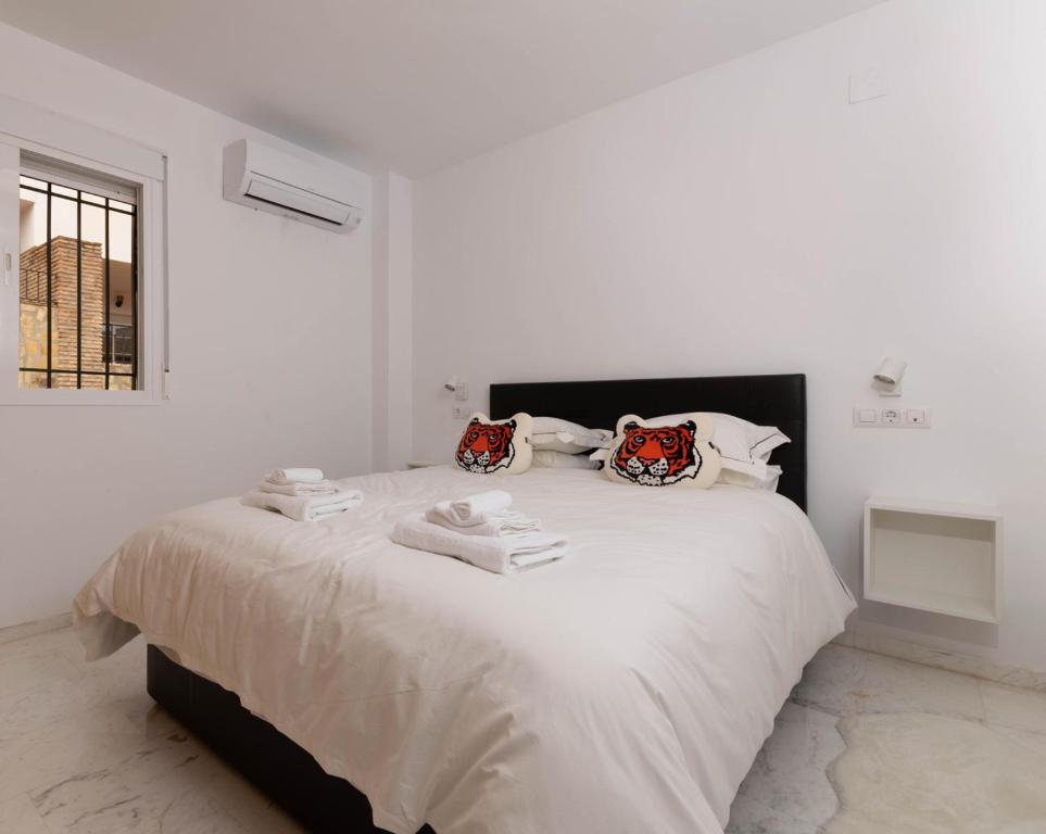 biała sypialnia z dużym łóżkiem i ręcznikami w obiekcie Luxury Penthouse: The Beacon at Punta de la Mona w Almuñécar