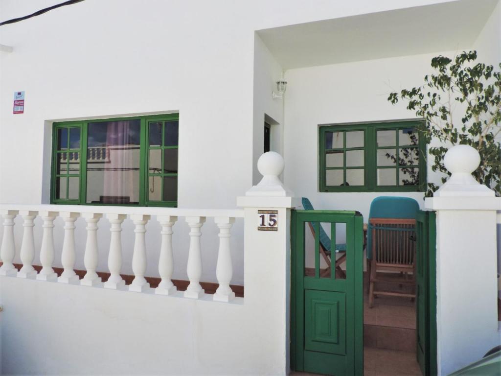 a house with white walls and green doors at CASA ANGELINA in Playa Quemada