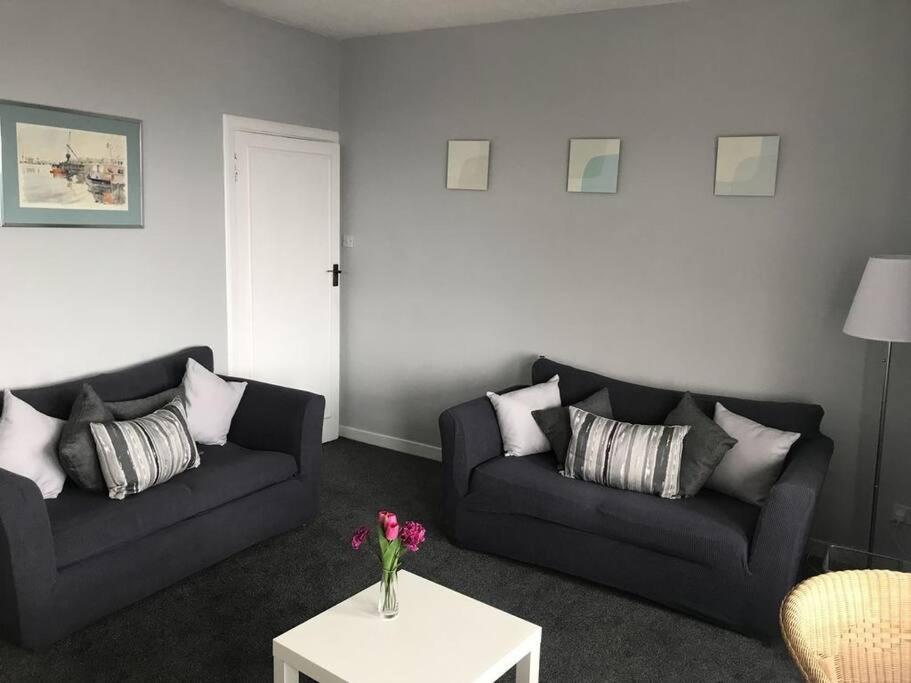 a living room with two couches and a table at Cumbrae View Apartment Largs in Largs