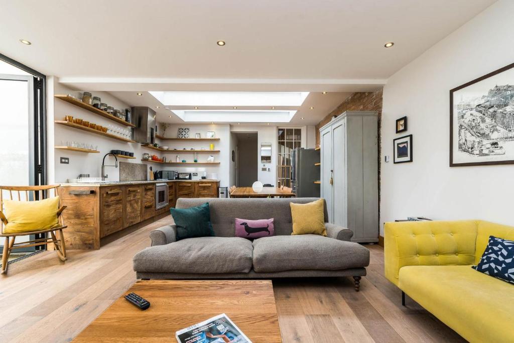 uma sala de estar com um sofá e uma cozinha em Stunning 3BD Flat Shoreditch with Hidden Garden em Londres