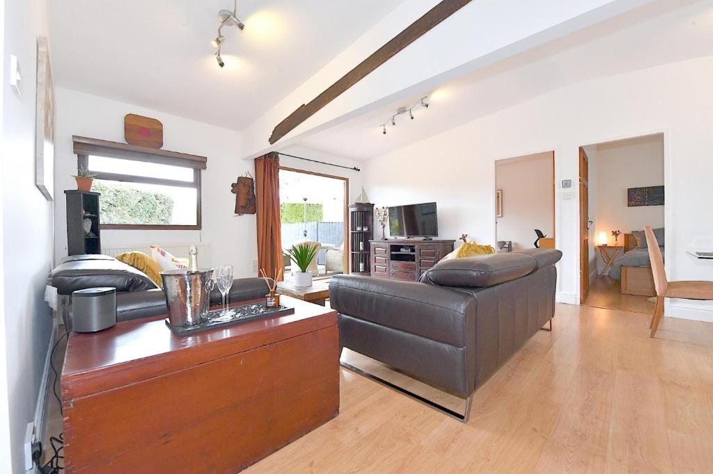 un soggiorno con divano e tavolo di Gorgeous 3BD Cottage in the Heart of Guildford a Guildford