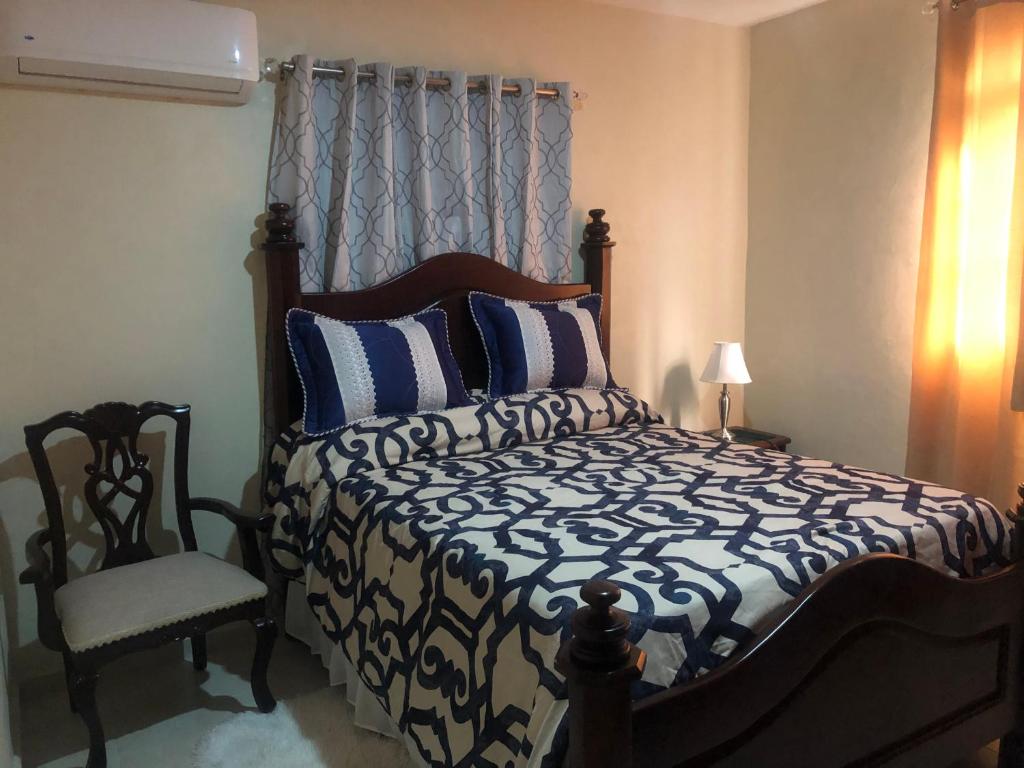 a bedroom with a bed and a chair in it at Apartamentos Kika in San Felipe de Puerto Plata