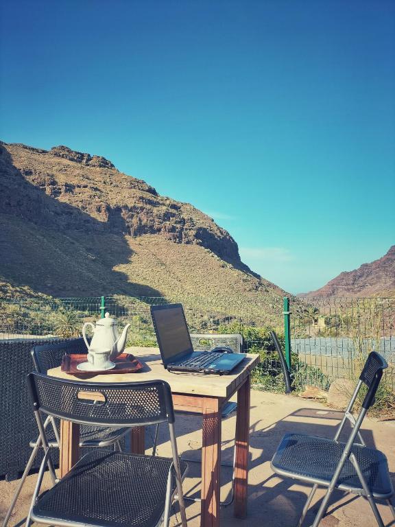 a laptop computer sitting on a table with two chairs at Casas Blancas - Suite 3 in Tasartico
