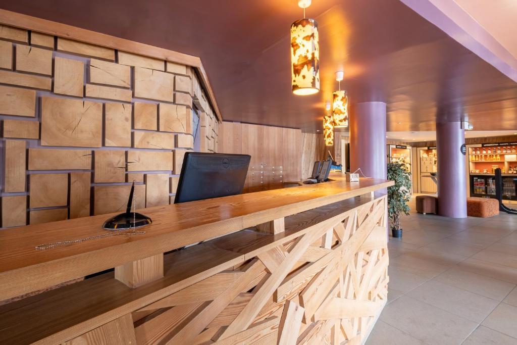 a lobby with a wooden reception counter with a wall at Résidence Pierre & Vacances Atria-Crozats in Avoriaz