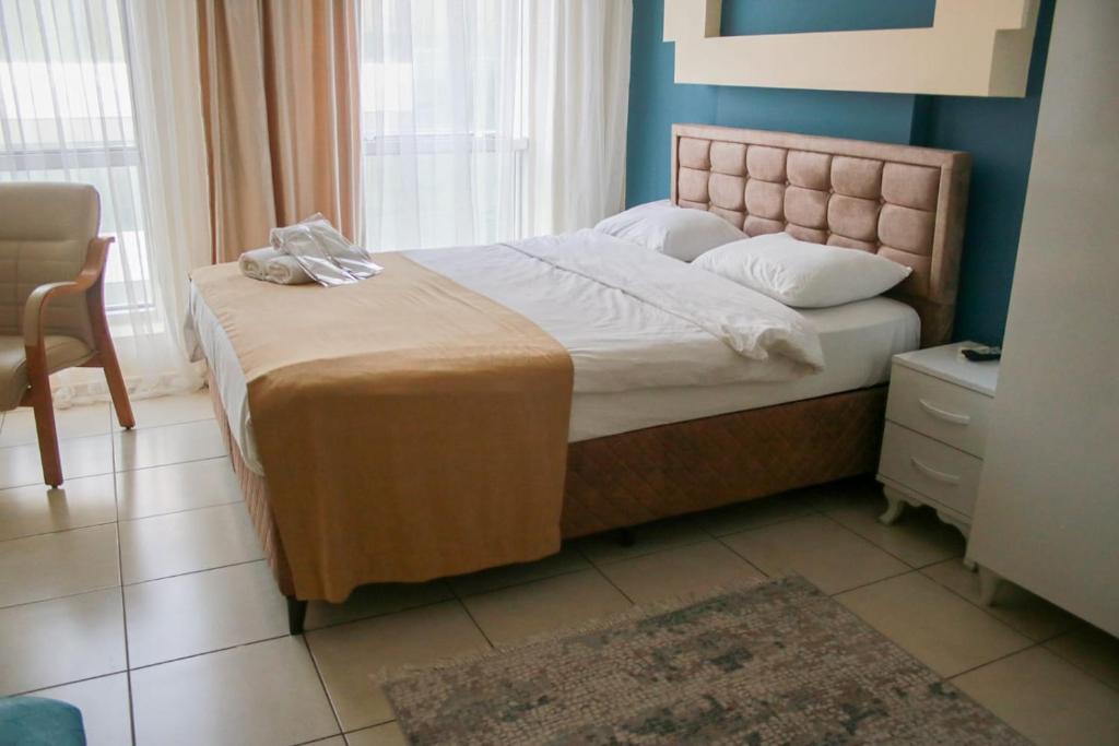 a bedroom with a bed and a chair at Daisy Hotel in İzmir