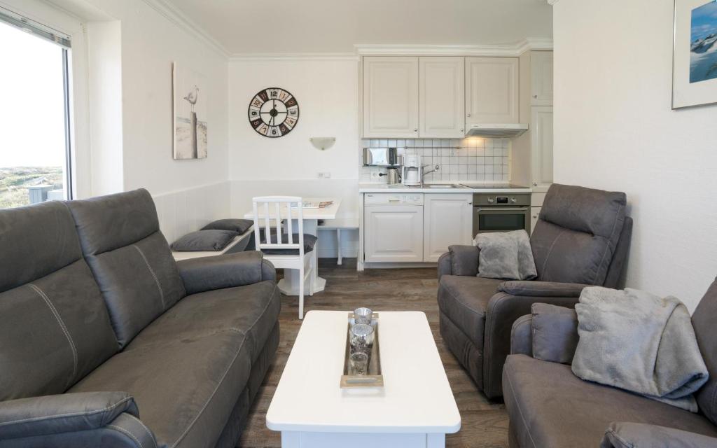 ein Wohnzimmer mit 2 Sofas und einem Tisch in der Unterkunft App.8 Seeblick in Hörnum