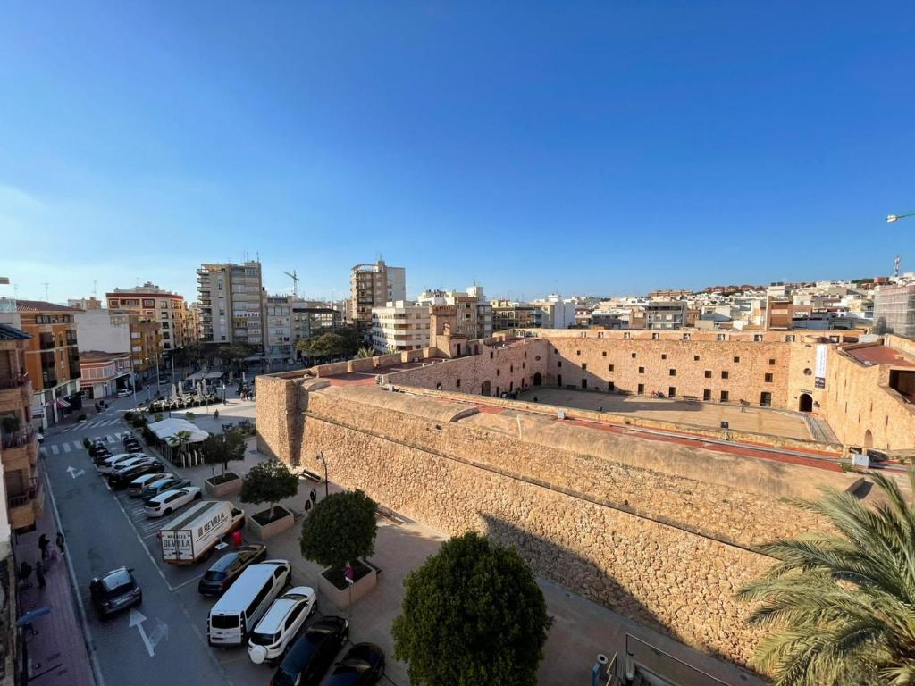 une ville avec des voitures garées à côté d'un grand mur en briques dans l'établissement Central loft apartments, à Santa Pola