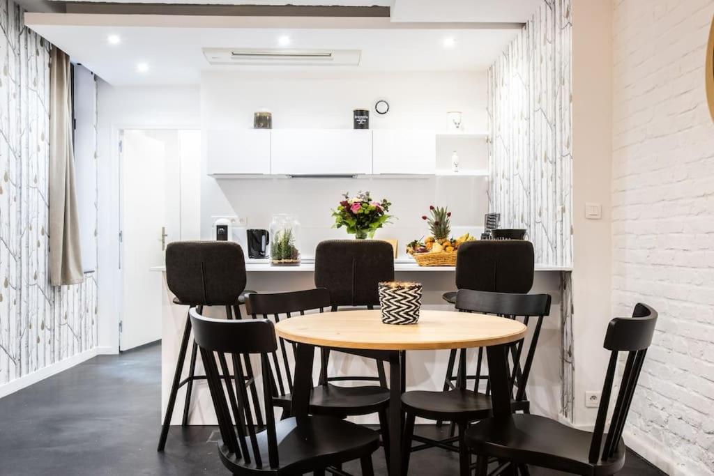 una sala da pranzo con tavolo e sedie nere di Flandres Appart' Hotel par NOCNOC - Schepers a Lille