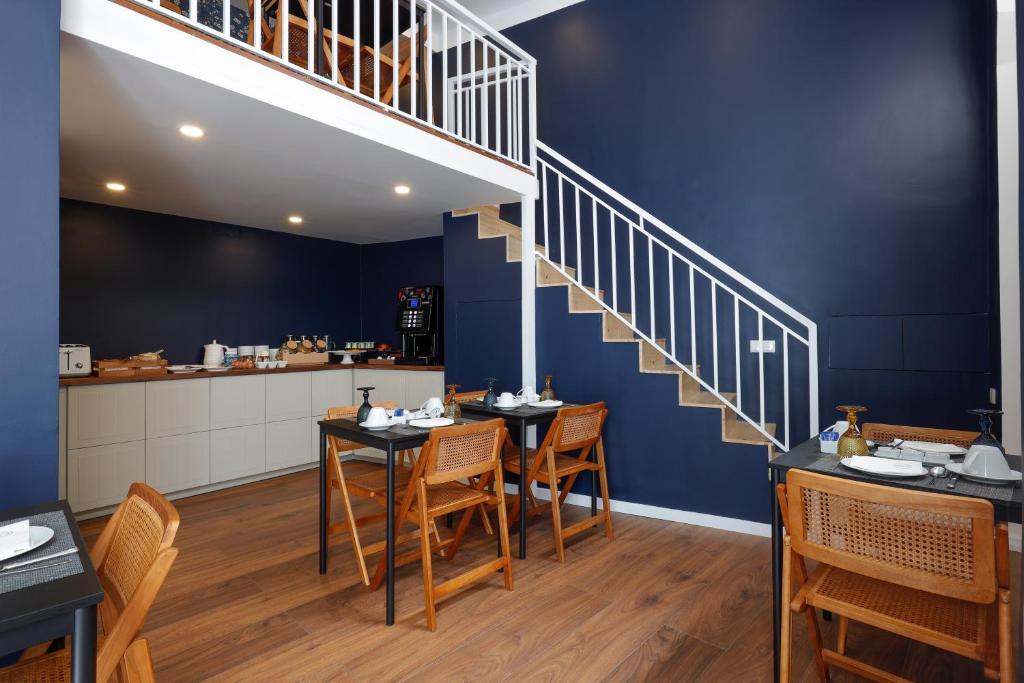 a dining room with a staircase and tables and chairs at 1869 Príncipe Real House in Lisbon