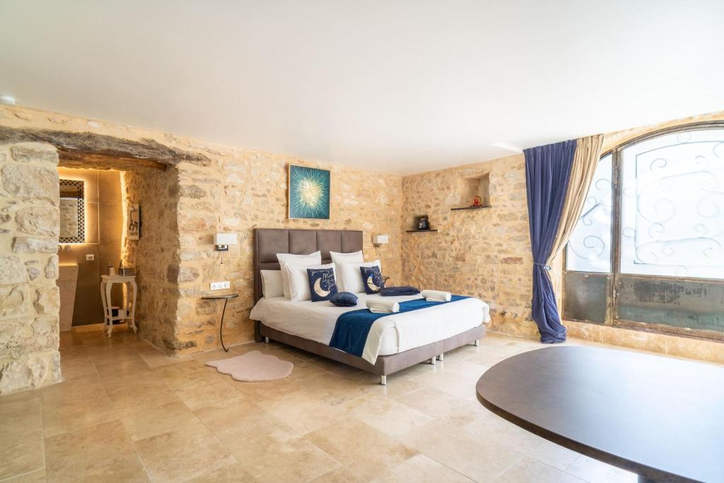 Un dormitorio con una cama y una mesa. en Chambre d'hôte avec SPA privatif domaine les nuits envôutées - Gard, en Vézénobres