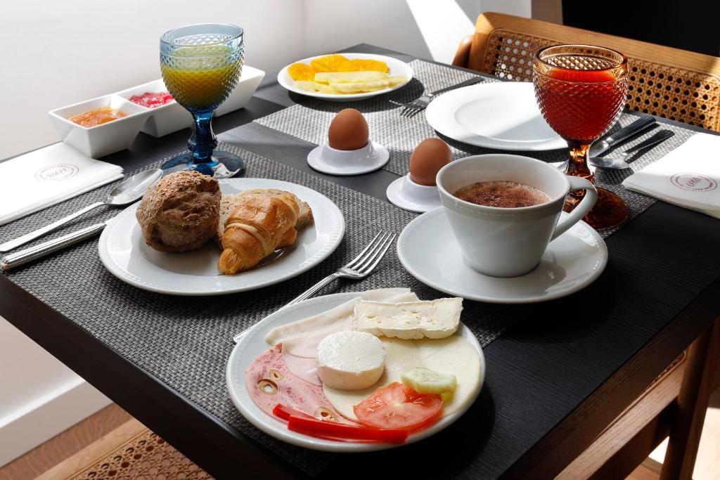 a table with plates of food and cups of coffee at 1869 Príncipe Real House in Lisbon