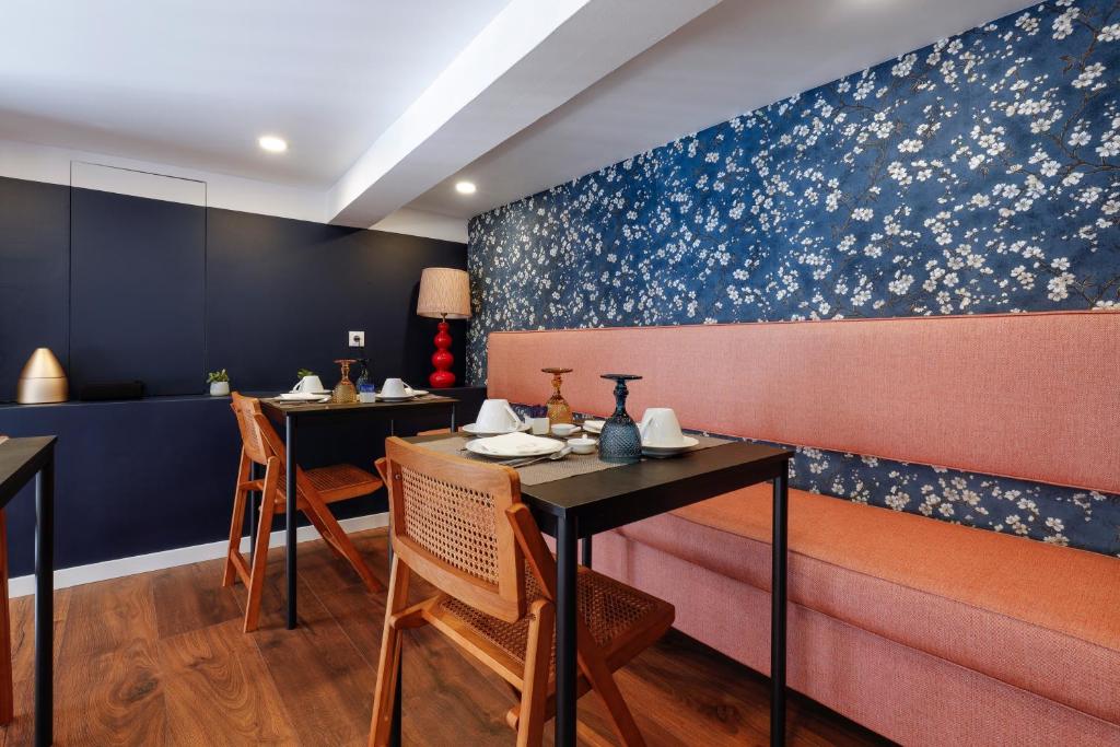 a dining room with two tables and a bench at 1869 Príncipe Real House in Lisbon
