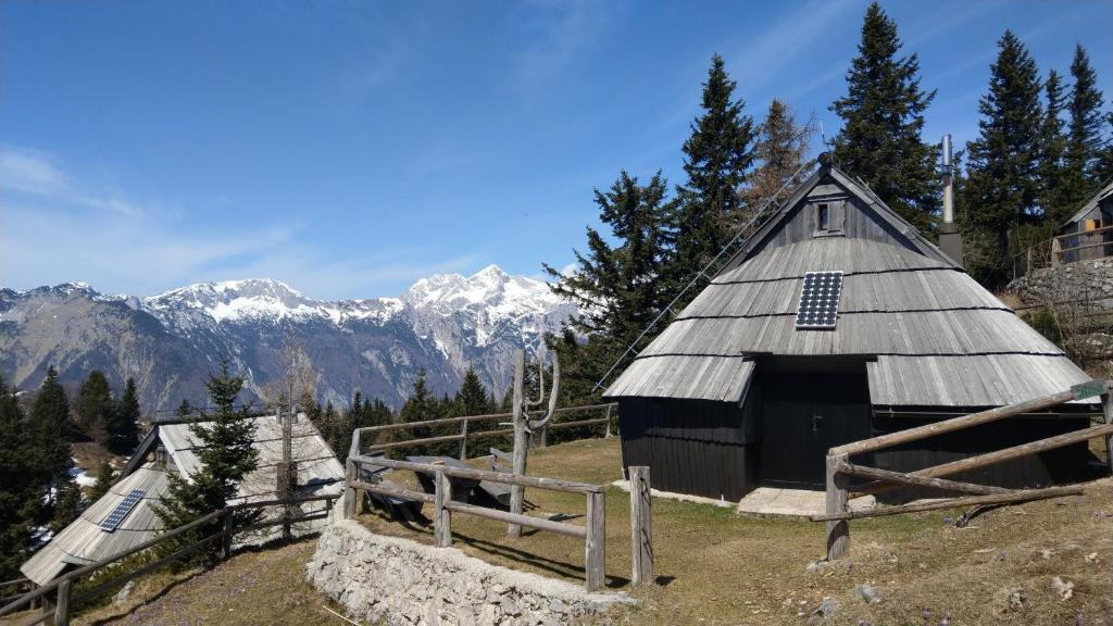 un granero en una colina con montañas en el fondo en Chalet Resa - Velika planina, en Stahovica