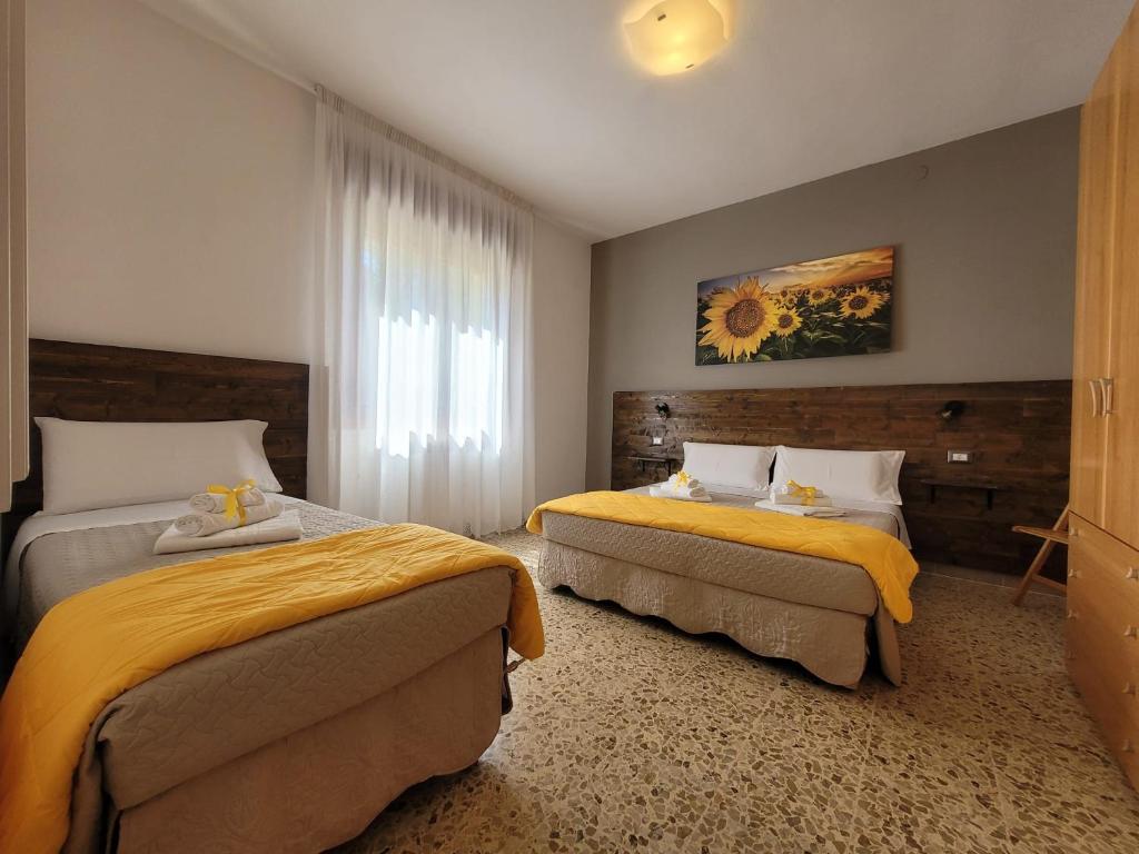 una camera d'albergo con due letti e una finestra di Antonella's Home a Cavallino-Treporti