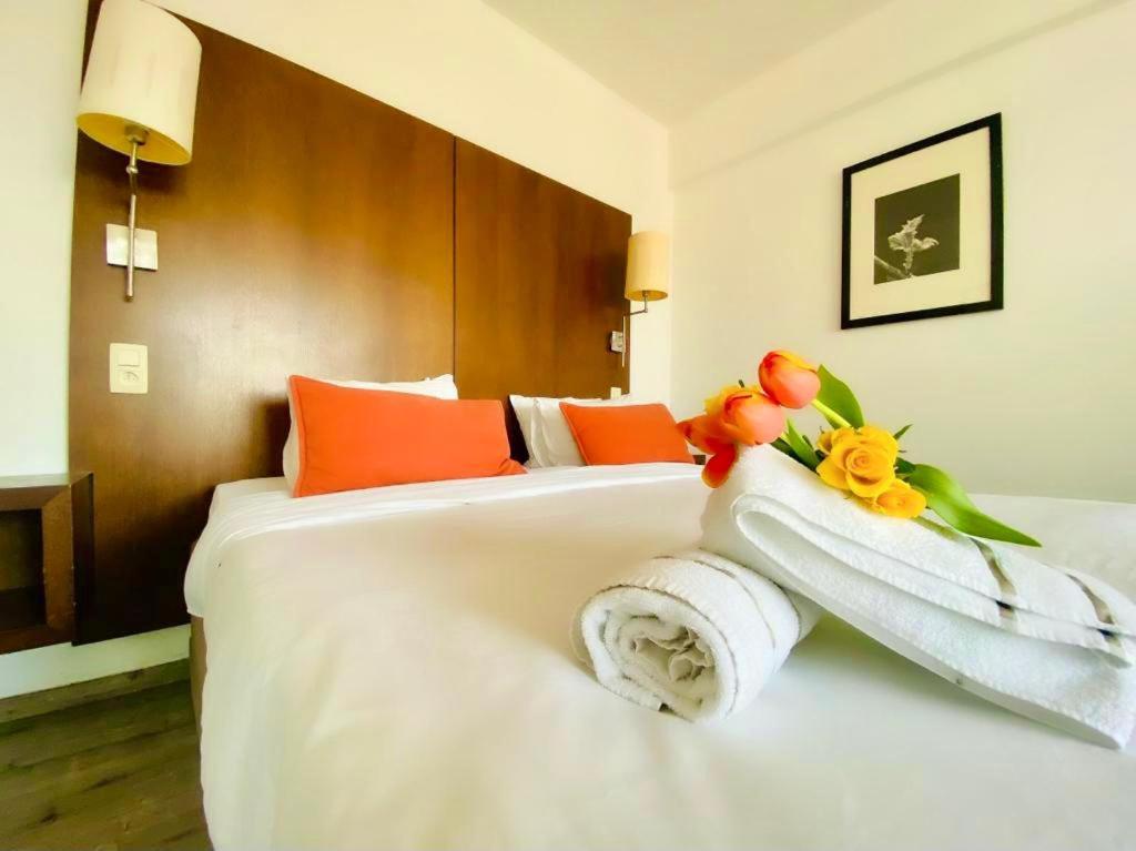 um quarto de hotel com uma cama com toalhas e flores em Centerstay Brussels em Bruxelas