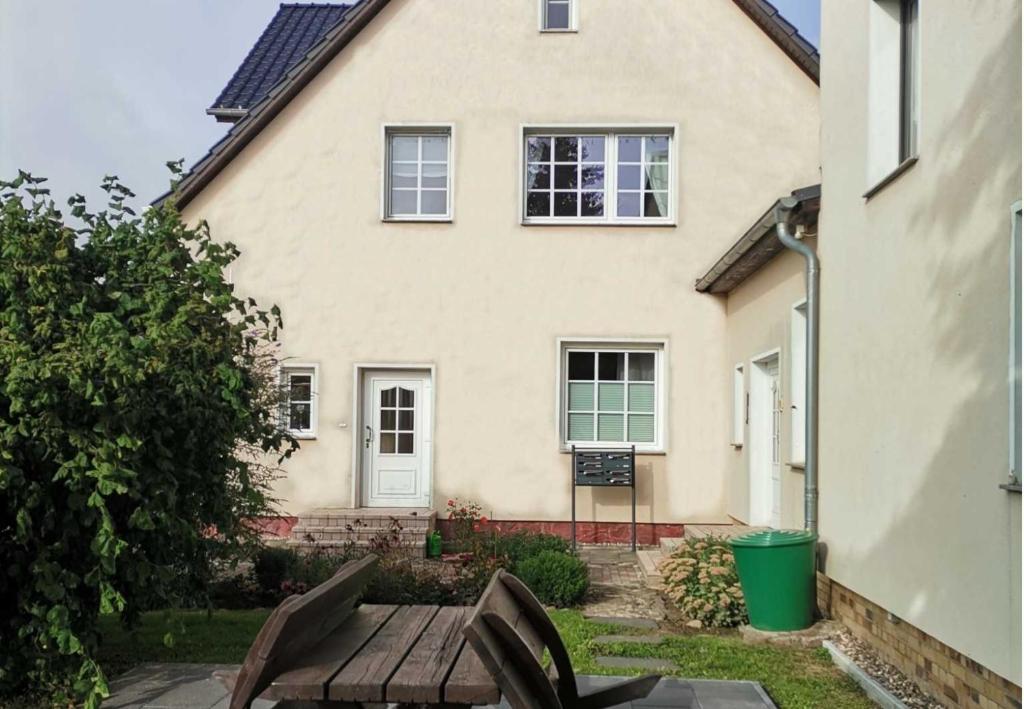 a white house with a wooden bench in front of it at Peene Alte Schule Völschow Dornberger 