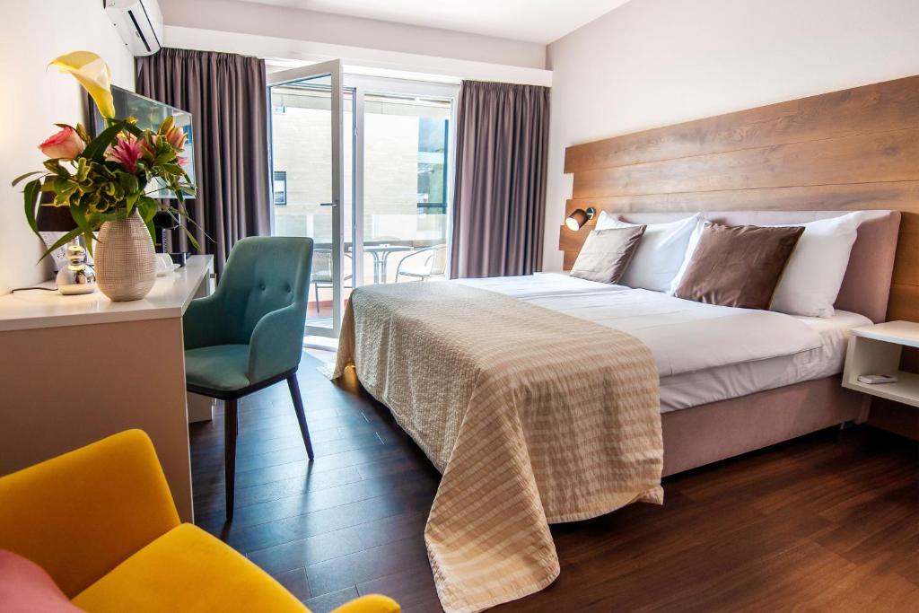 アスコナにあるHotel Poloのベッドと椅子付きのホテルルーム