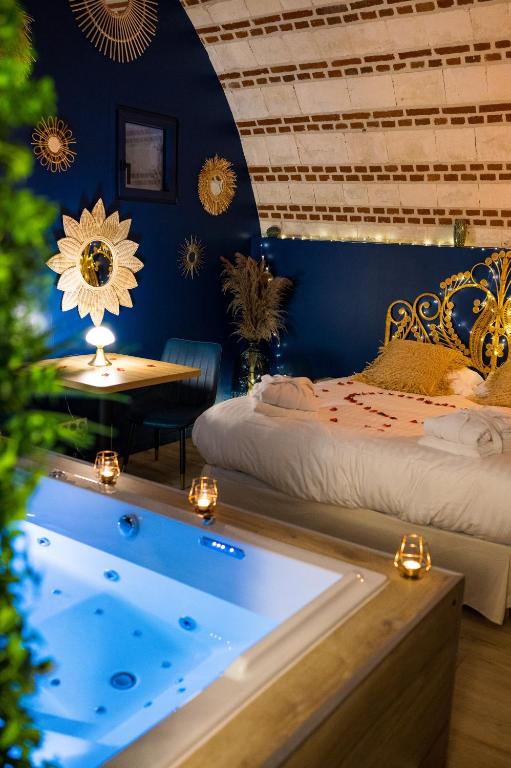 a room with two beds and a tub in it at La Parenthèse Envoutée in Amiens