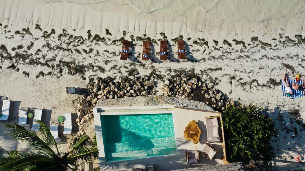 TV frente a una pared con calcetines y piscina en Hotel Boutique Casa Muuch Holbox - Solo Adultos en Holbox Island