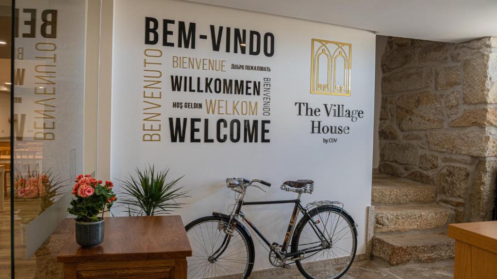 a bike is parked next to a wall with signs at The Village House by CDV in Carrazeda de Anciães
