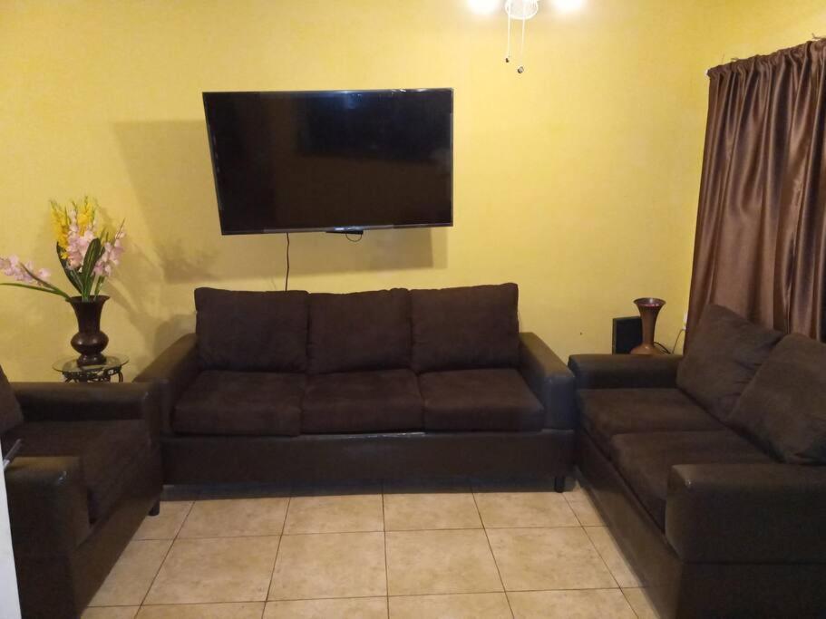 sala de estar con sofá y TV de pantalla plana en Casa completa en privada y con cochera, en Monclova