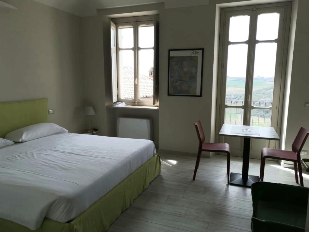 - une chambre avec un lit, une table et deux chaises dans l'établissement OLIVOLA APARTMENTS, à Frassinello Olivola