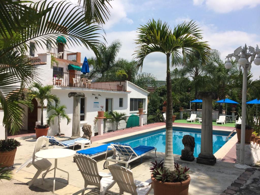 a resort with a swimming pool and palm trees at Hotel Bajo el Volcan in Cuernavaca
