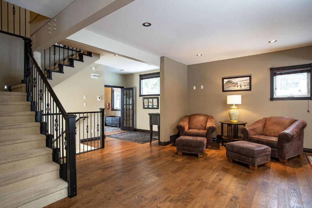 a living room with two chairs and a staircase at Mountain Gateway by Revelstoke Vacations in Revelstoke