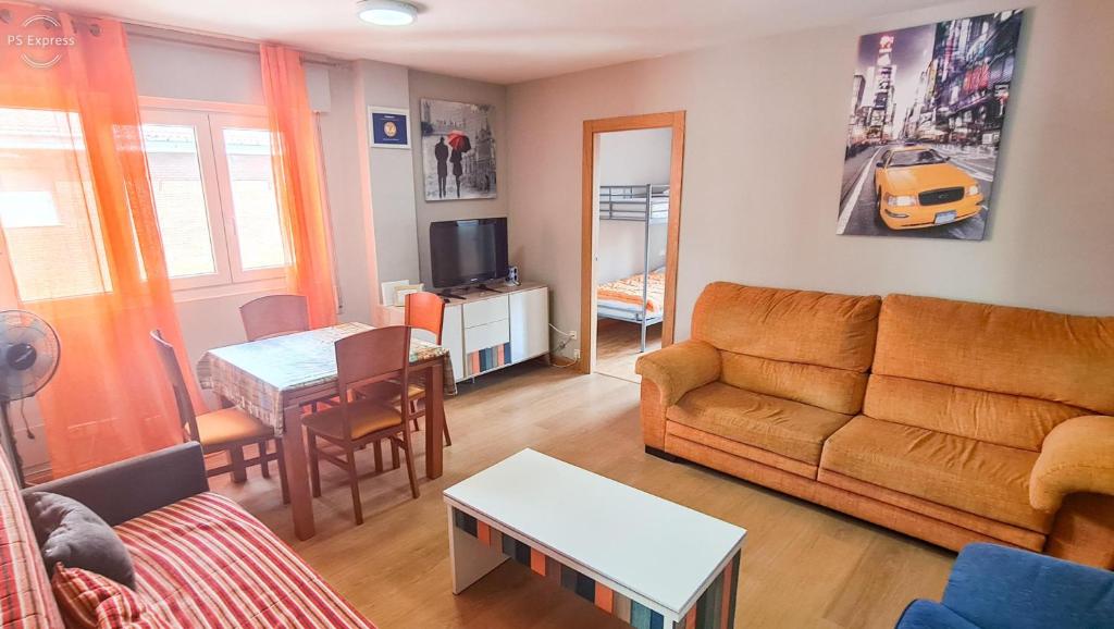 een woonkamer met een bank en een tafel bij www apartamentovaldivia es Parking incluido in León