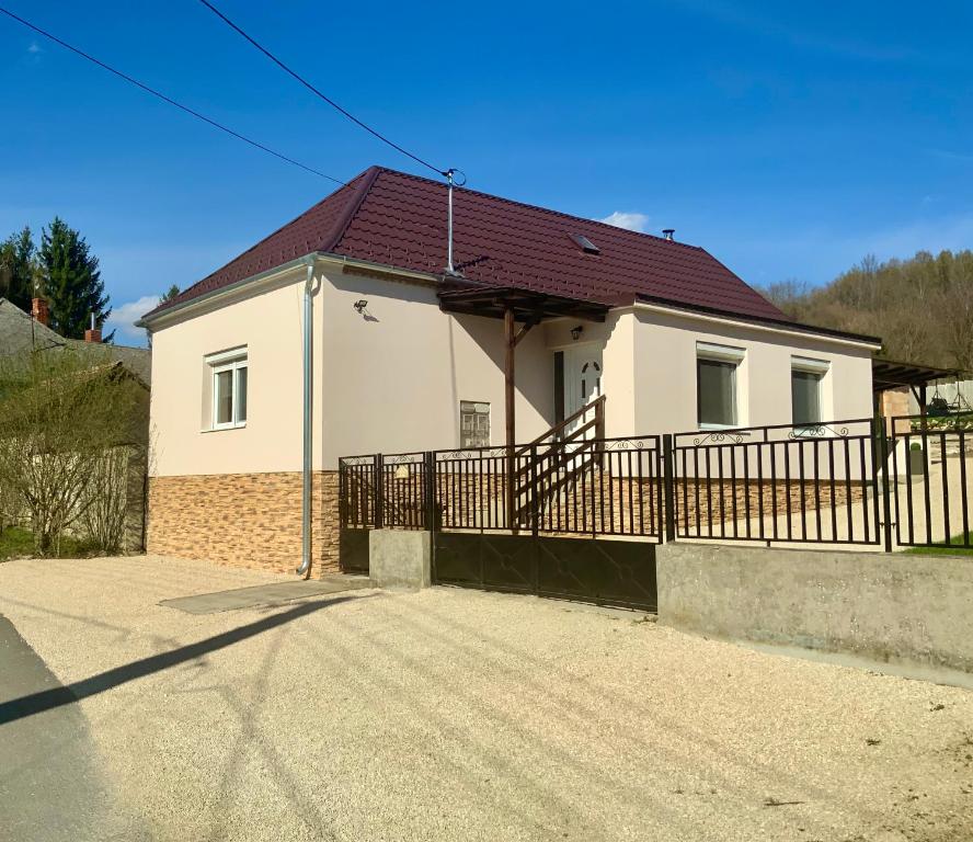 uma casa branca com uma cerca à frente. em Milano Vendégház em Bakonybél