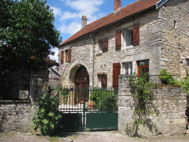 una antigua casa de piedra con una puerta verde en La Maison de Claire en Flavigny-sur-Ozerain