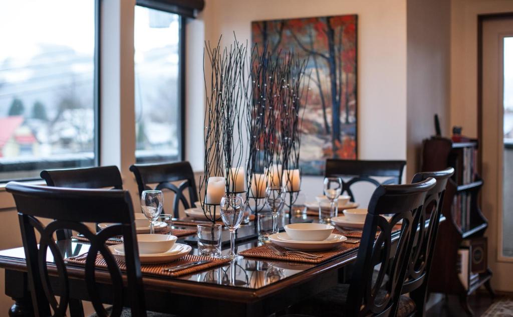 a dining room table with chairs and glasses on it at Alpenglow Penthouse by Revelstoke Vacations in Revelstoke