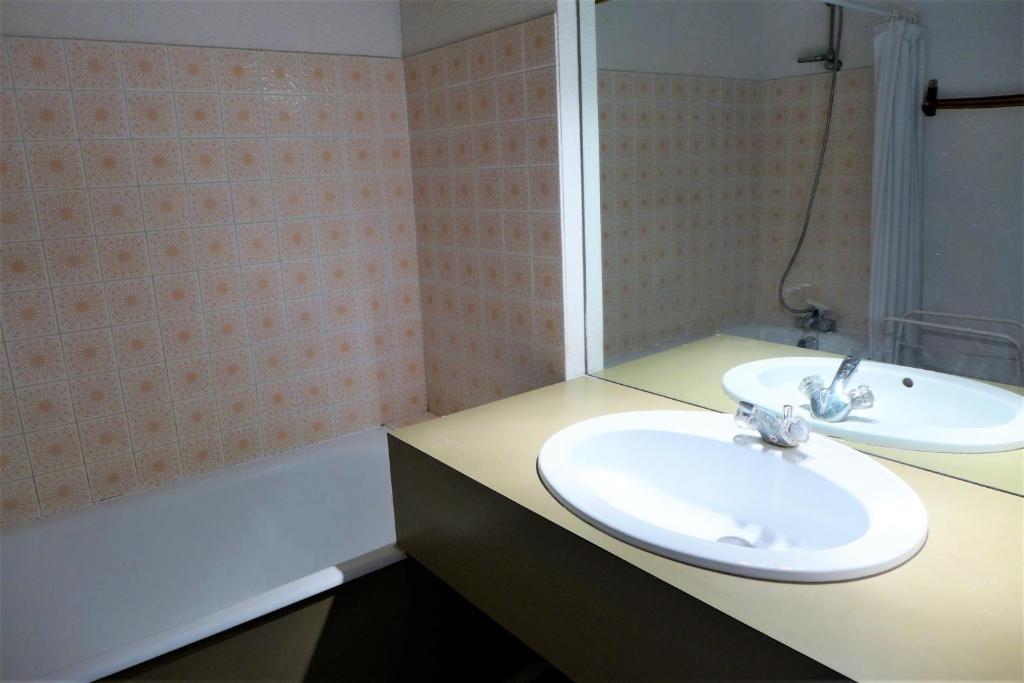 a bathroom with a sink and a bath tub at Réf 543, Seignosse Océan, Appartement avec aperçu Mer, à 150m de la plage, 4 personnes in Seignosse