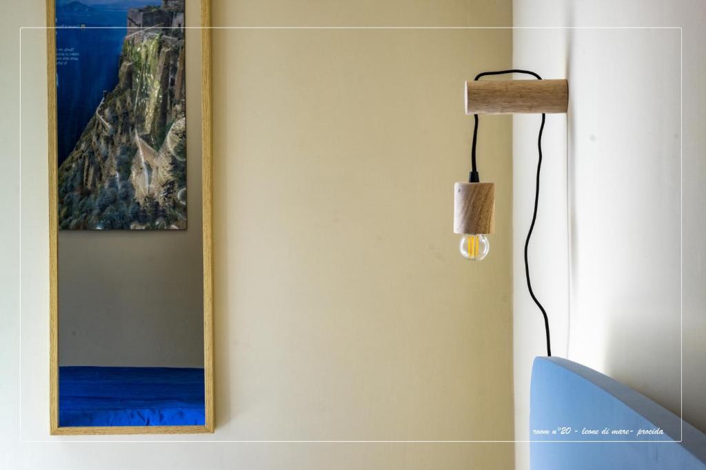 a mirror hanging on a wall next to a lamp at Il Leone Di Mare in Procida