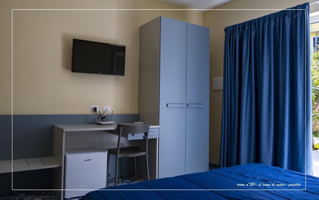 a bedroom with a bed and a desk with a tv at Il Leone Di Mare in Procida