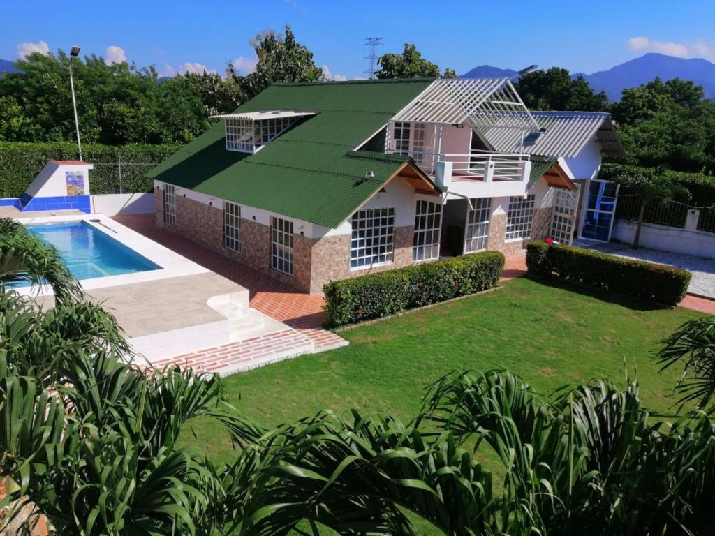 una casa con techo verde y piscina en Cabaña Karibeña, en Santa Marta