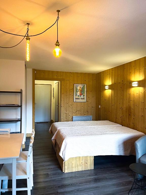 une chambre avec un grand lit et une table et des chaises dans l'établissement 2- Studio Brides-les-bains tout confort avec vue Vanoise, à Brides-les-Bains