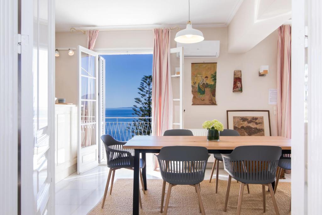 a dining room with a table and chairs and a large window at Corfu town tranquility gem in Corfu Town