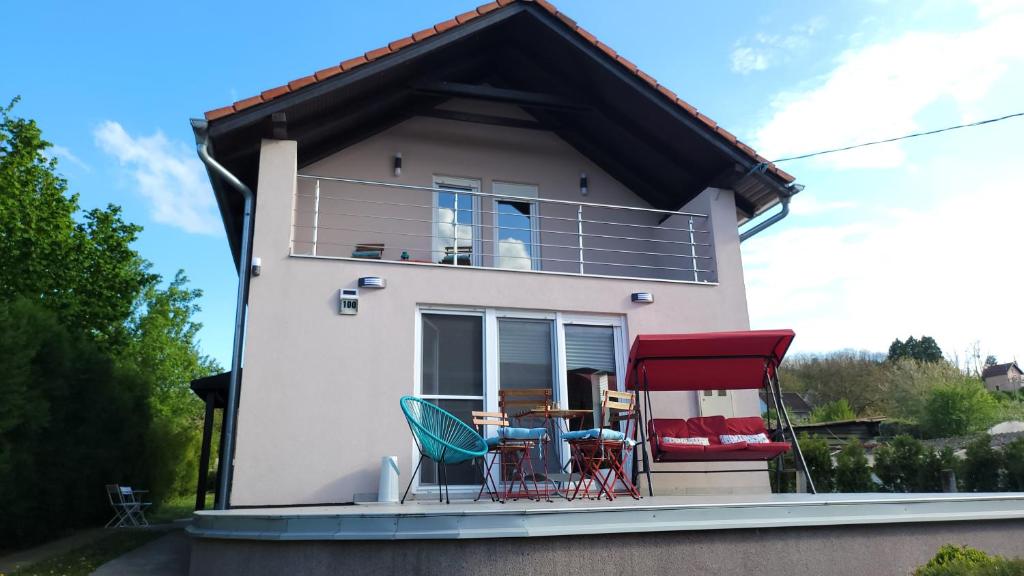 a house with chairs and a table on the balcony at Ivančica in Aljmaš