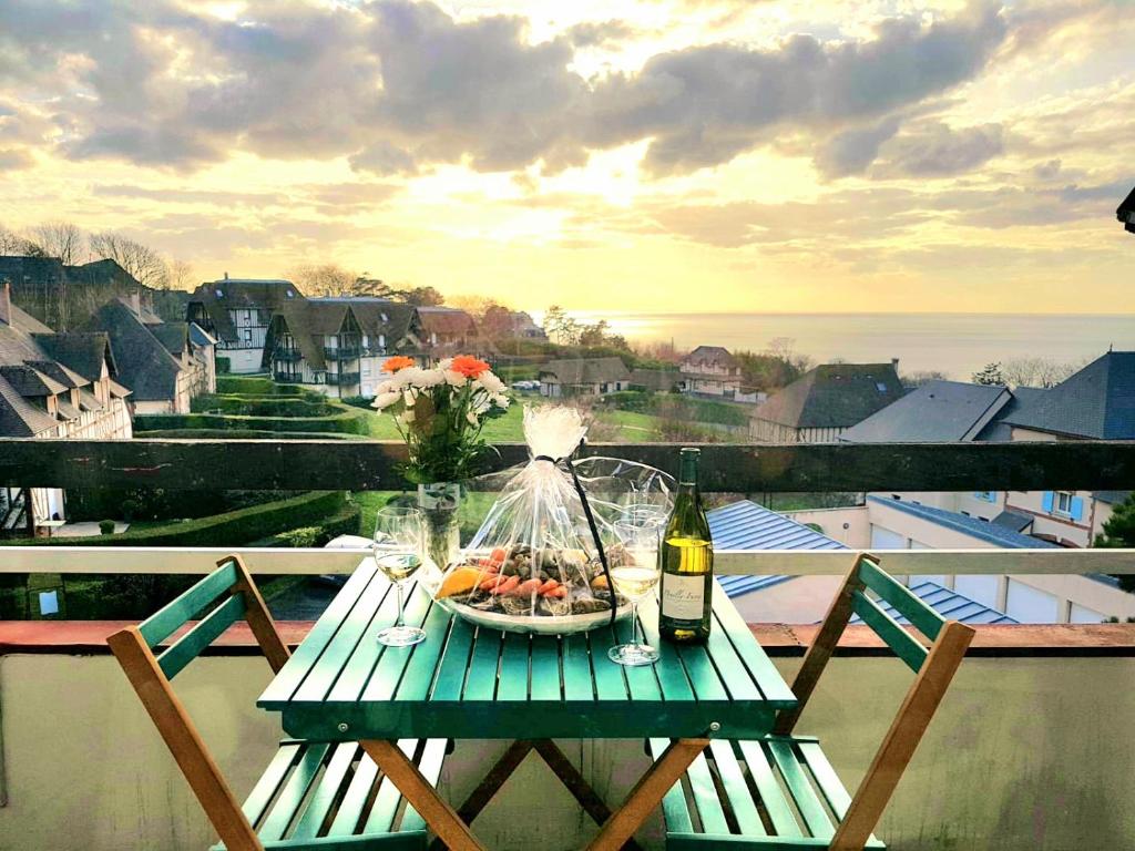 - une table avec une assiette de fruits et une bouteille de vin dans l'établissement 2/3 Pièces - Balcon Vue Mer - Parking, à Trouville-sur-Mer