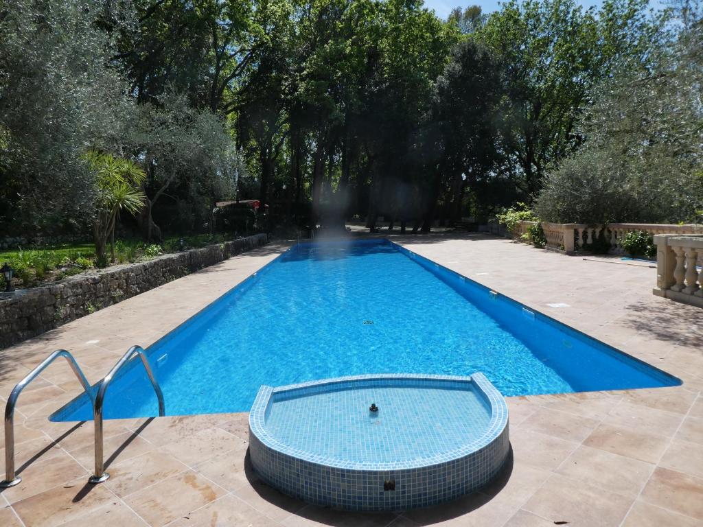 a swimming pool with a tub in a yard at Domaine du Paradis des Oiseaux in Mougins